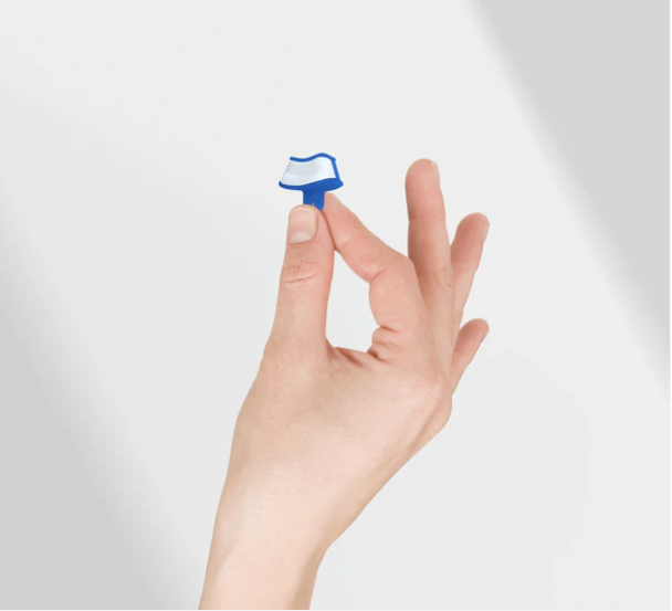 Eine Hand hält den snorley zwischen zwei Fingern – kaum größer als eine Fingerkuppe.